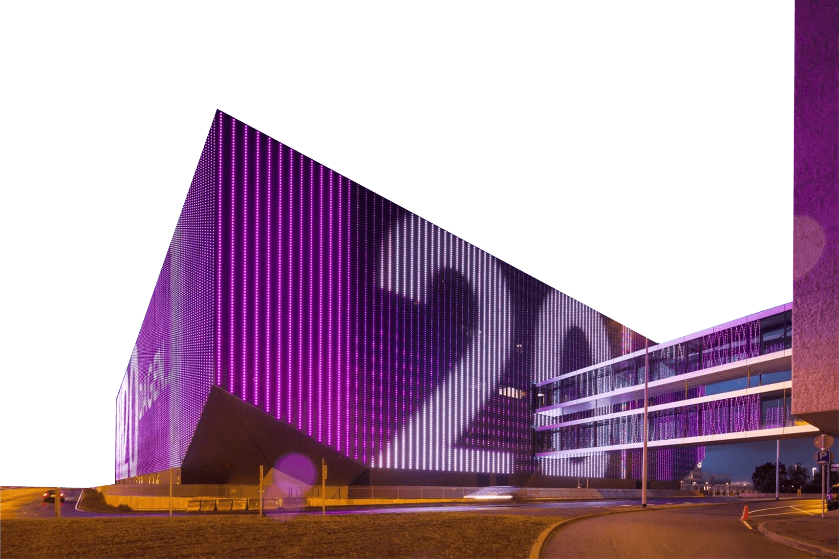 Ziggo Dome with purple LED lights displays large numbers. It's situated beside a road with streetlights, under a twilight sky.