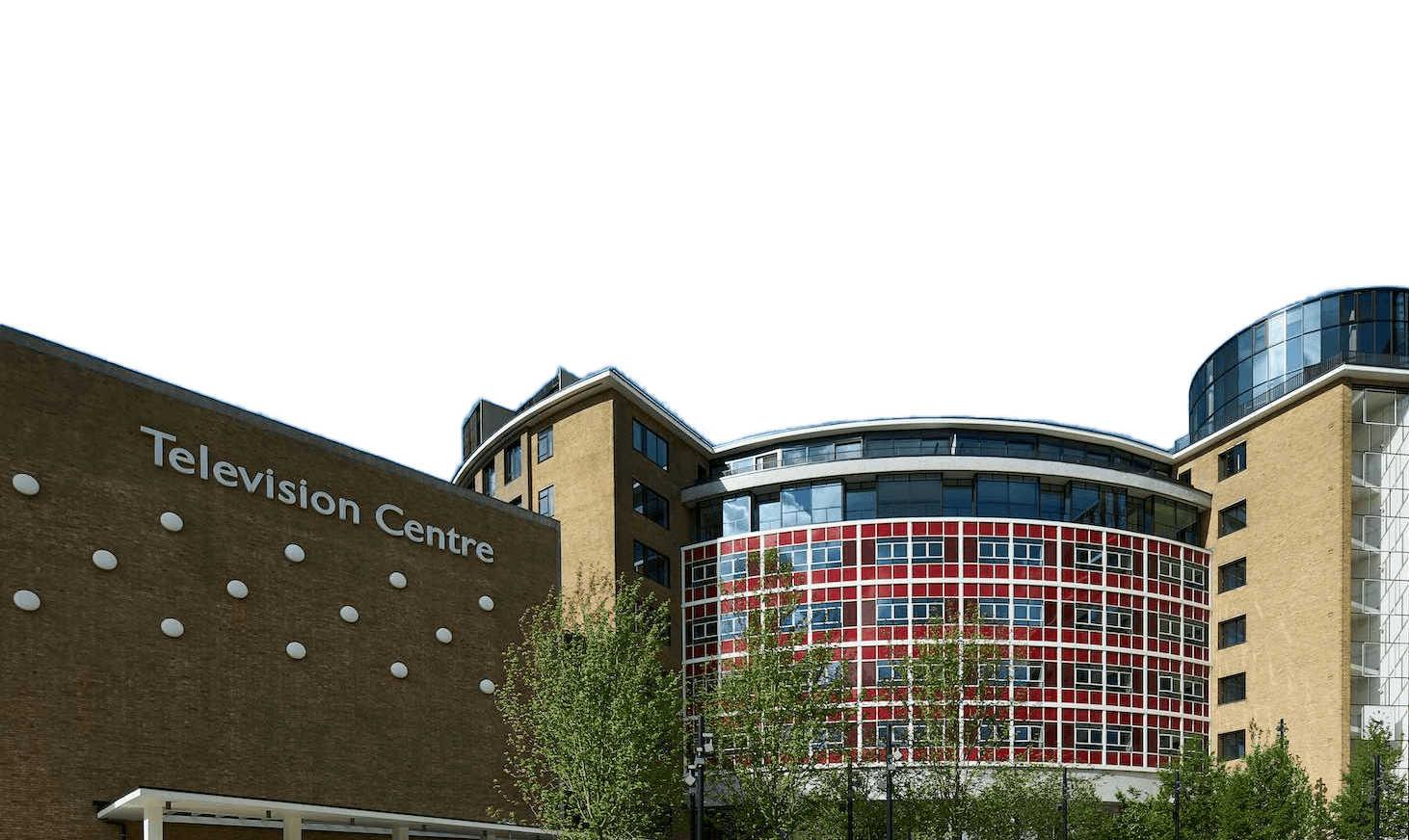 A modern building complex with a sign reading "Television Centre" on a brown brick wall, set against a blue sky with scattered clouds.