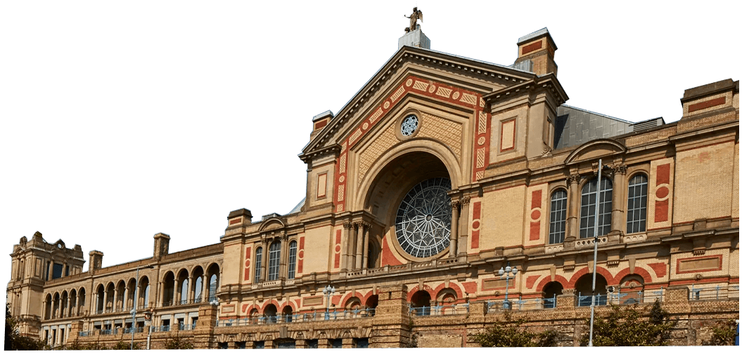 Alexandra Palace with a detailed facade, featuring a central rose window and other intricate architectural elements under a clear blue sky.