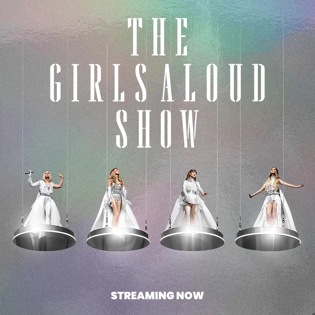 Girls Aloud in white costumes stand on suspended circular platforms under the text "The Girls Aloud Show." The background is a gradient, with "Streaming Now" written at the bottom.