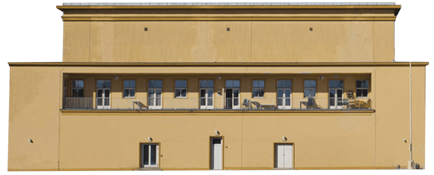 A flat, beige building with multiple windows and two doors on the lower section. The design is simple and geometric, with a blue sky and a few clouds in the background.